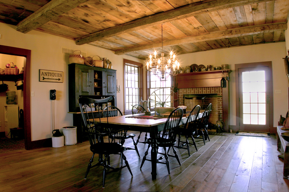 Esempio di una grande sala da pranzo rustica con pareti beige, parquet chiaro, camino classico e cornice del camino in mattoni