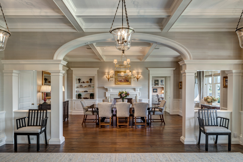 Imagen de comedor clásico renovado con paredes beige, suelo de madera en tonos medios y todas las chimeneas