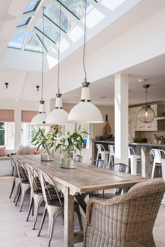 Foto di una grande sala da pranzo aperta verso il soggiorno stile marino con parquet chiaro