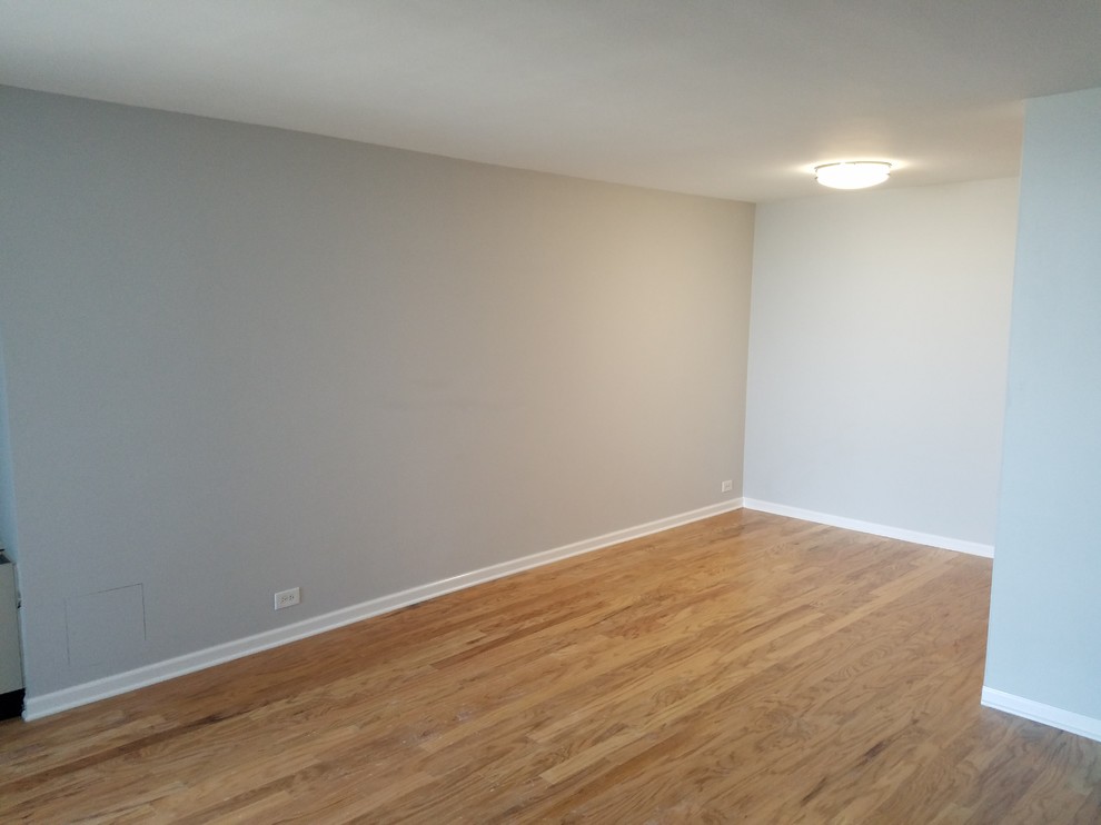 Immagine di una sala da pranzo aperta verso il soggiorno minimal di medie dimensioni con pareti grigie, pavimento in legno massello medio, nessun camino e pavimento marrone