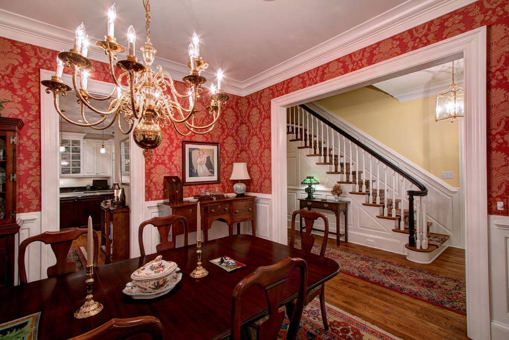 Photo of a large classic enclosed dining room in Charlotte with red walls, medium hardwood flooring and no fireplace.