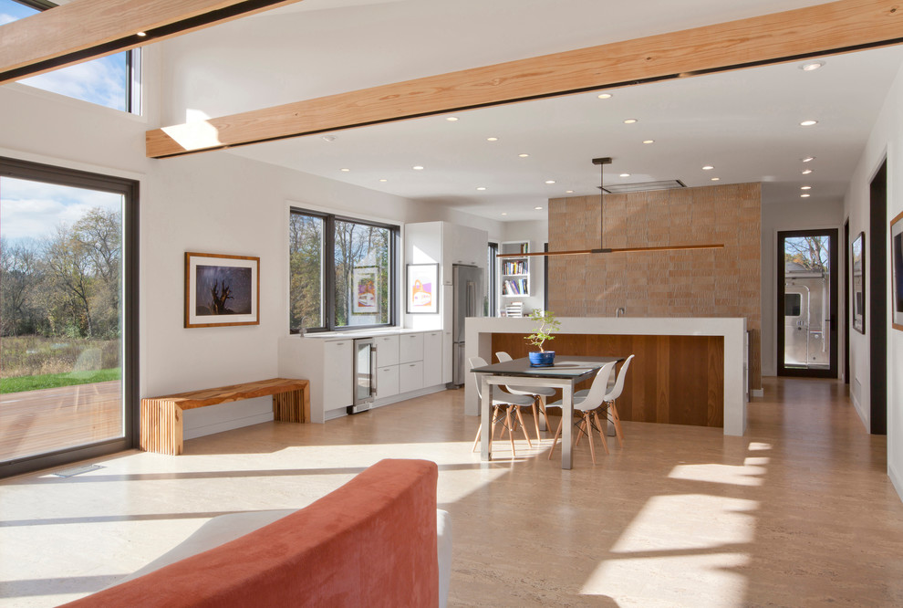 Immagine di una sala da pranzo aperta verso la cucina contemporanea di medie dimensioni con pareti bianche, pavimento in sughero e pavimento beige