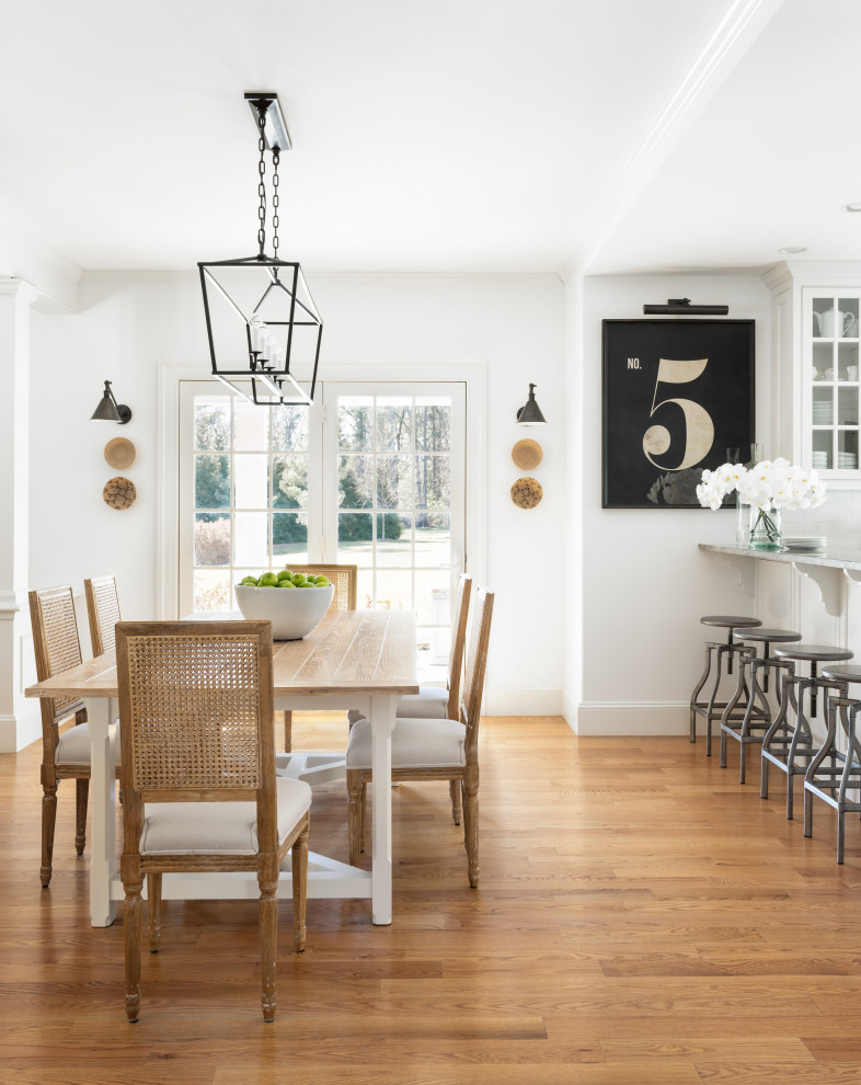 Idee per una sala da pranzo chic con pareti bianche, pavimento in legno massello medio e pavimento marrone