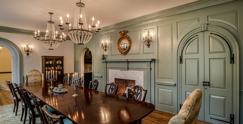 Inspiration pour une grande salle à manger ouverte sur le salon traditionnelle avec un mur blanc, une cheminée standard, un manteau de cheminée en pierre et un sol en bois brun.