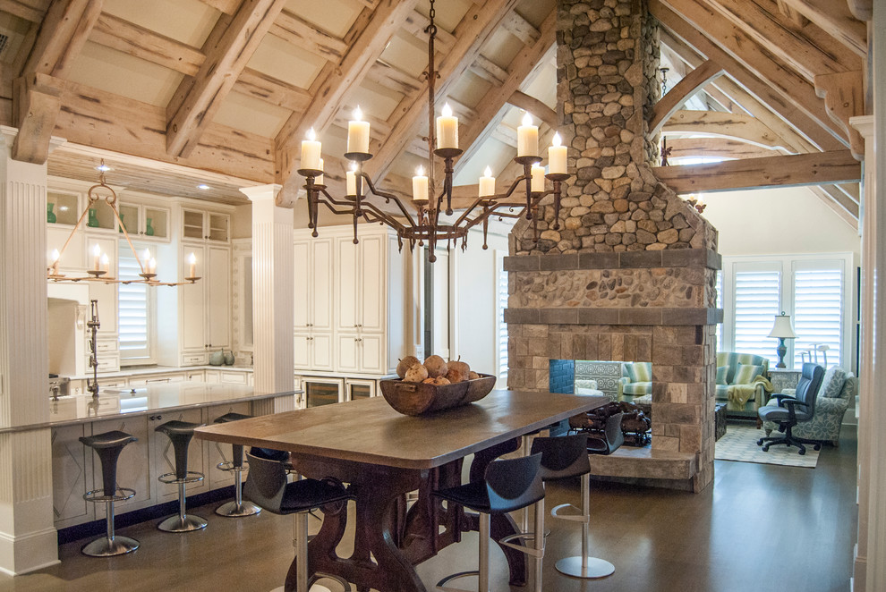Great room - rustic dark wood floor great room idea in Charleston with beige walls, a two-sided fireplace and a stone fireplace