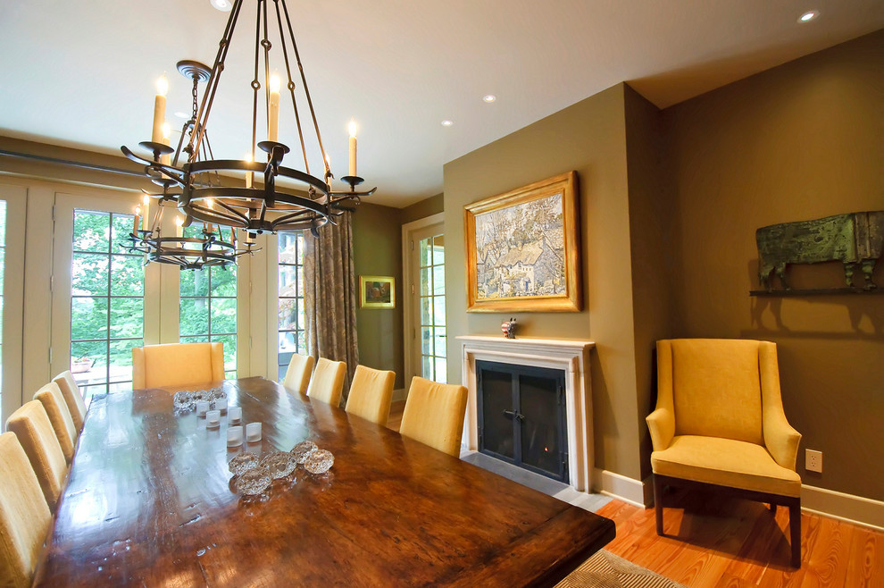 Example of a classic medium tone wood floor dining room design in Philadelphia with brown walls and a standard fireplace