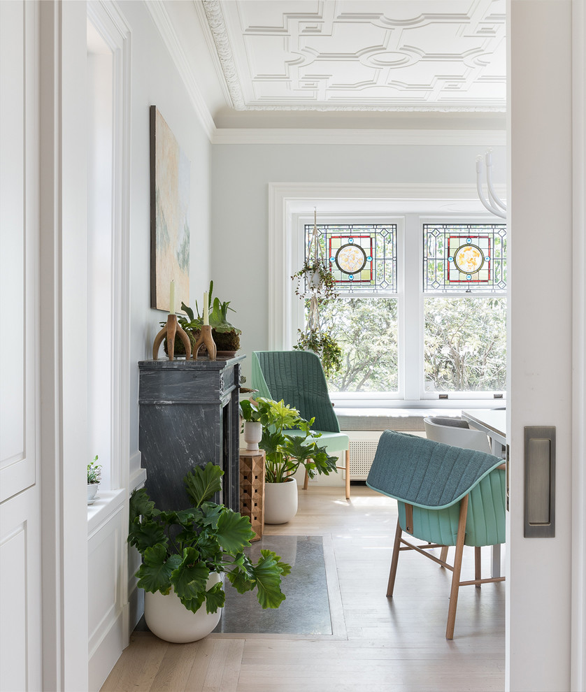 Источник вдохновения для домашнего уюта: отдельная столовая в скандинавском стиле с синими стенами, светлым паркетным полом, стандартным камином и фасадом камина из камня