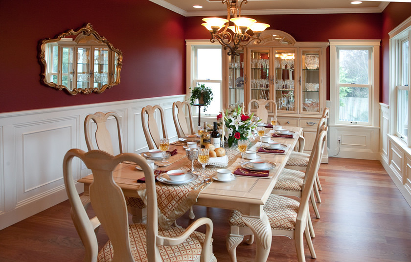 Immagine di una sala da pranzo vittoriana con pareti rosse e pavimento in legno massello medio