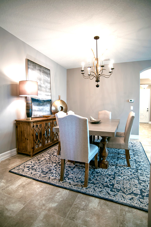 Photo of a medium sized traditional dining room in Orlando with grey walls, porcelain flooring, no fireplace, beige floors and feature lighting.