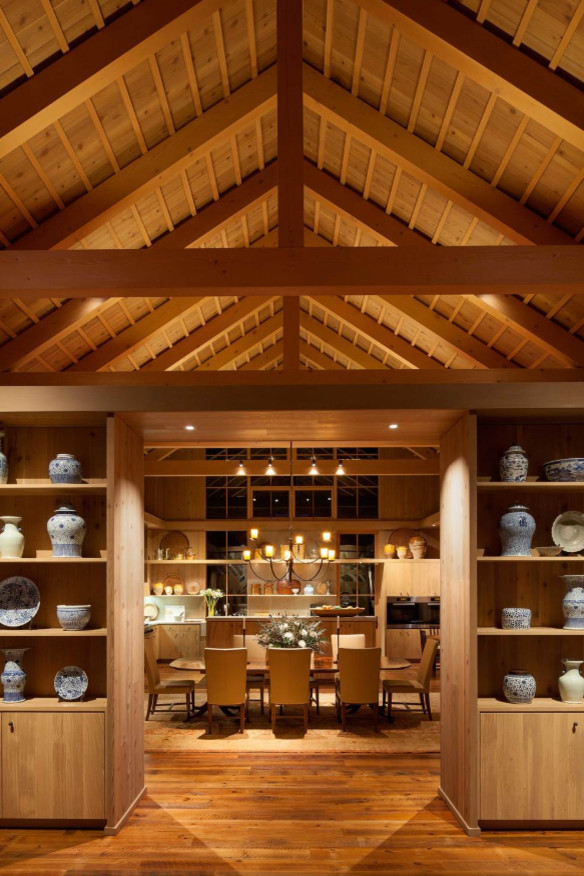 Immagine di una sala da pranzo aperta verso la cucina country con pareti marroni, pavimento in legno massello medio e pavimento marrone