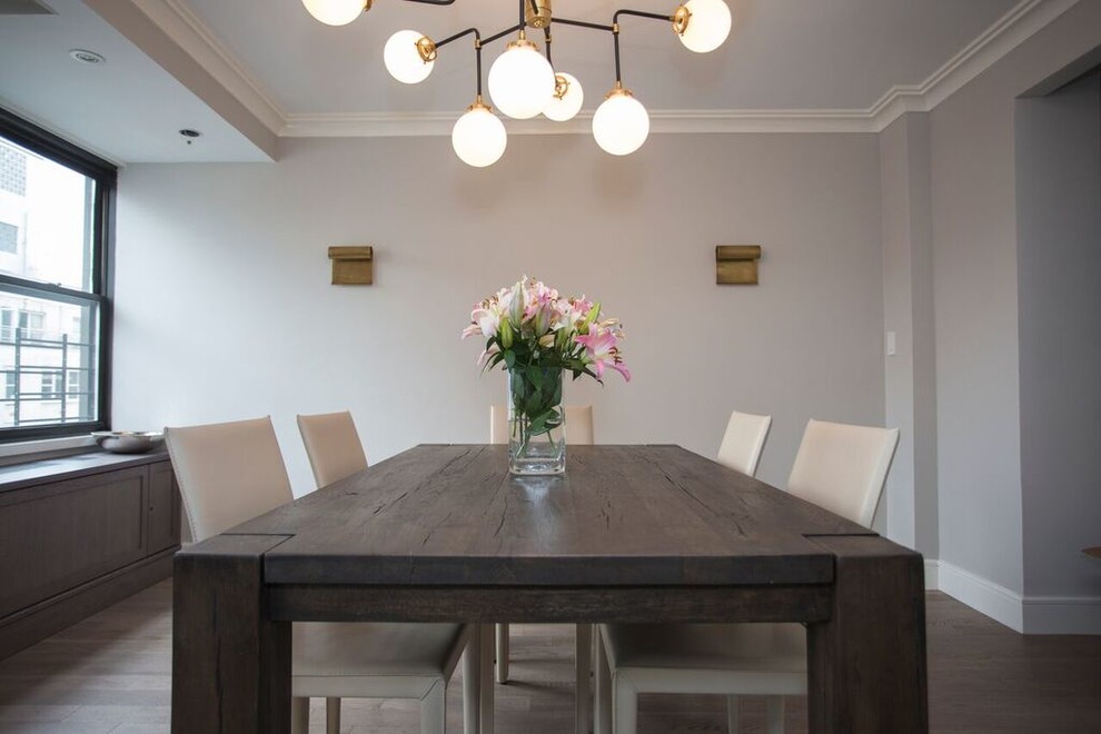 Foto di una sala da pranzo aperta verso il soggiorno classica con pareti grigie, parquet scuro e pavimento marrone