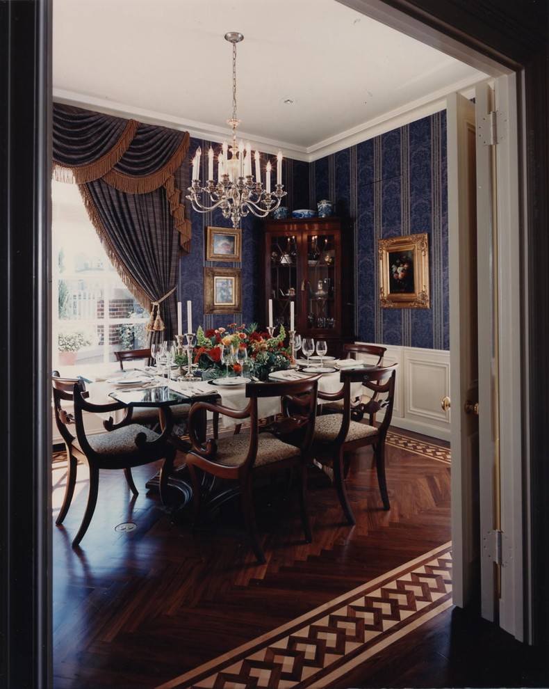 Exemple d'une salle à manger chic fermée et de taille moyenne avec un mur bleu, parquet foncé et un sol marron.