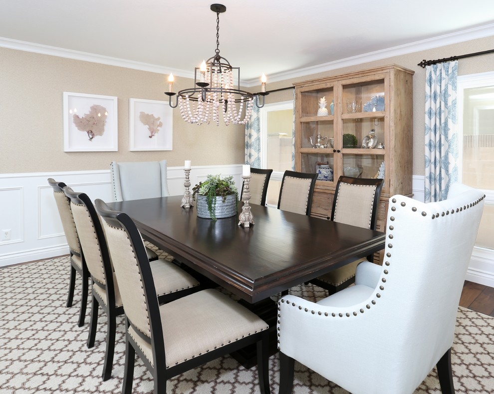 Example of a beach style medium tone wood floor enclosed dining room design in Orange County with beige walls