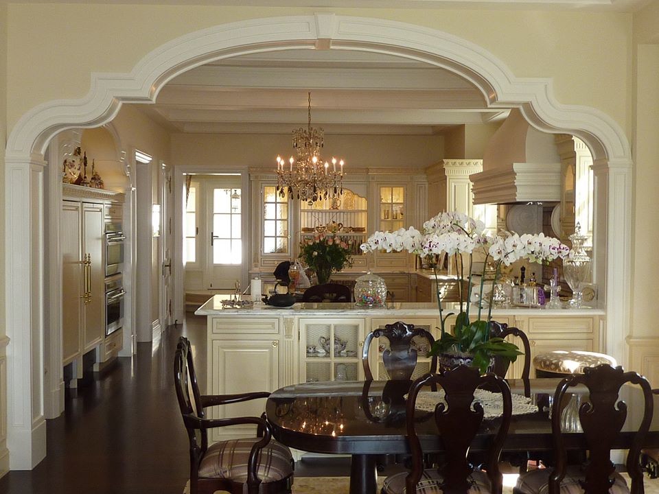 На фото: большая кухня-столовая в классическом стиле с желтыми стенами, темным паркетным полом и коричневым полом без камина с