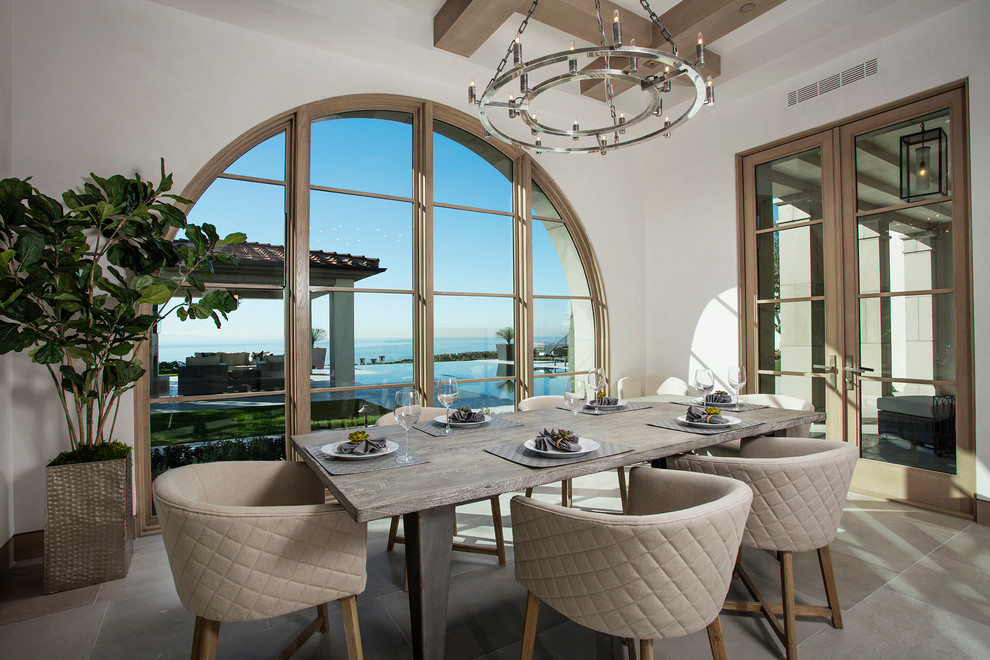 Example of a tuscan enclosed dining room design in Orange County with white walls