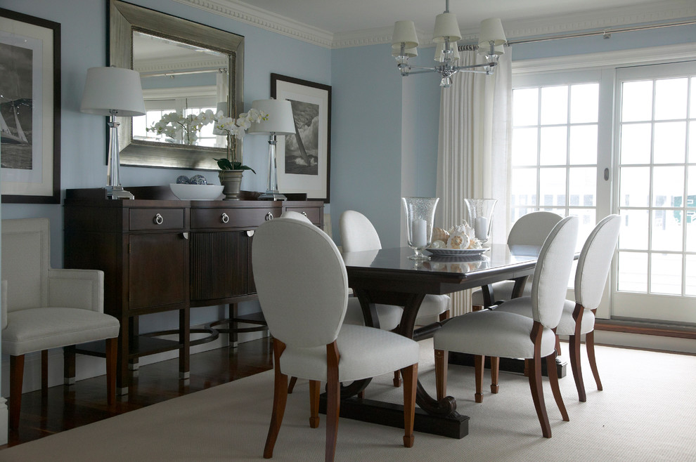 Photo of a coastal dining room in New York with blue walls, dark hardwood flooring and feature lighting.