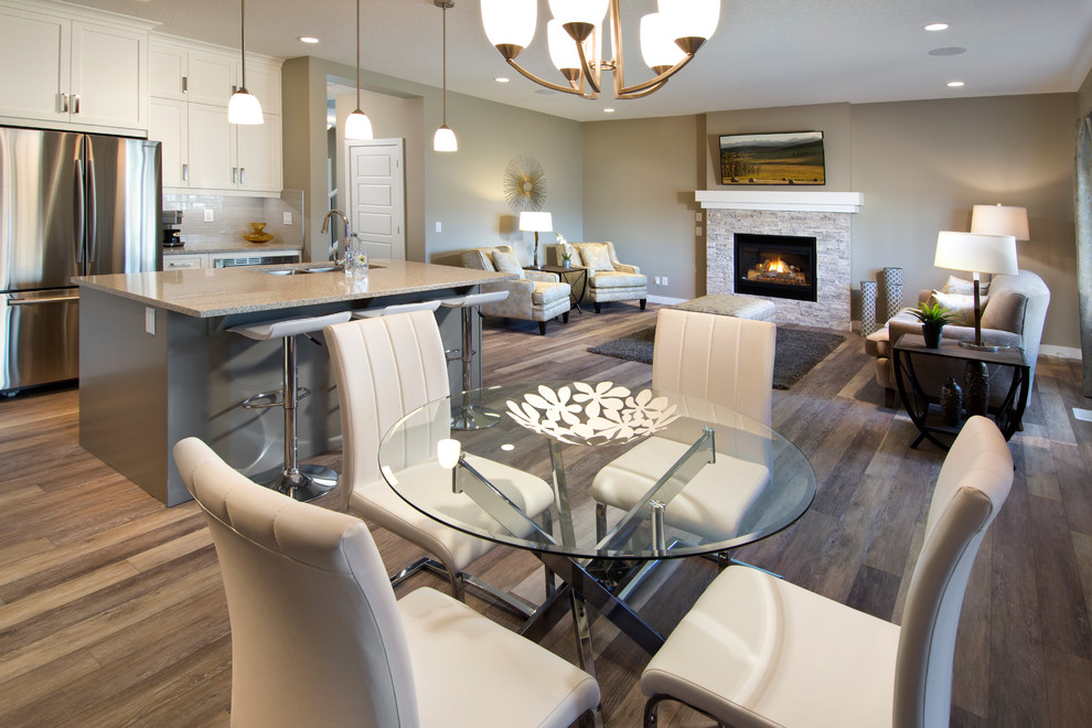 Large modern kitchen/dining room in Calgary with beige walls, no fireplace, medium hardwood flooring and a stone fireplace surround.