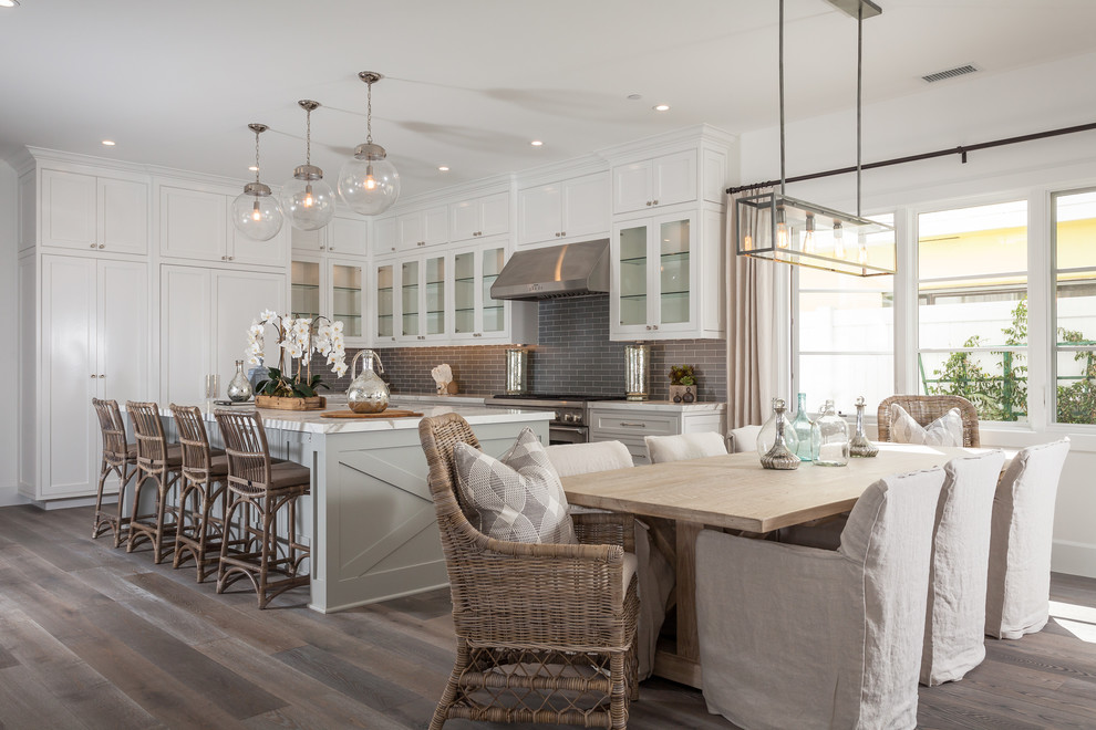 Dining room - large coastal dark wood floor dining room idea in Orange County with white walls