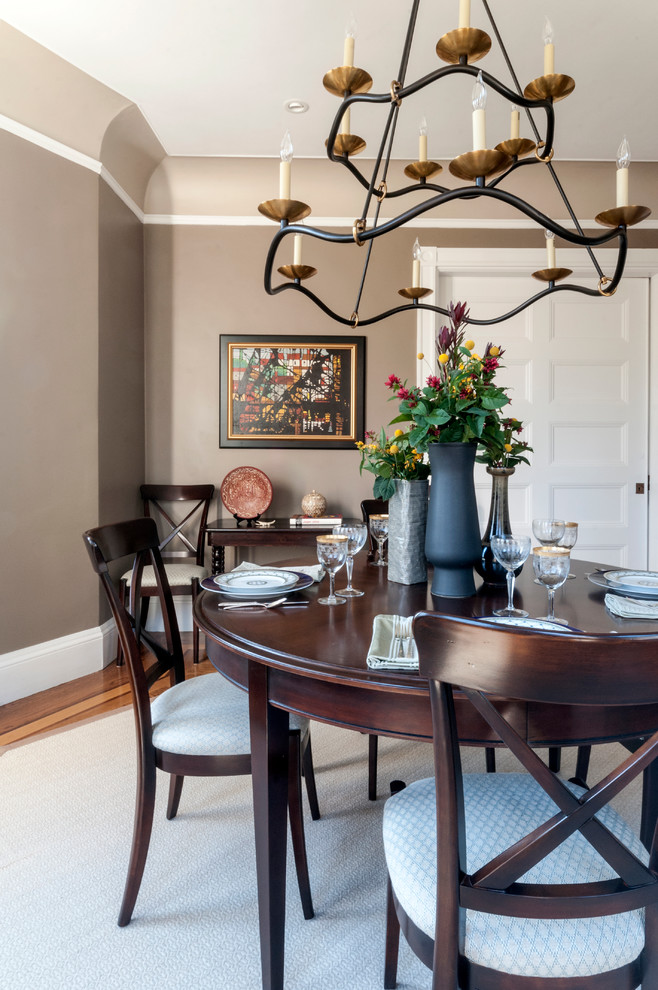 Immagine di una sala da pranzo classica chiusa con pareti marroni e parquet chiaro