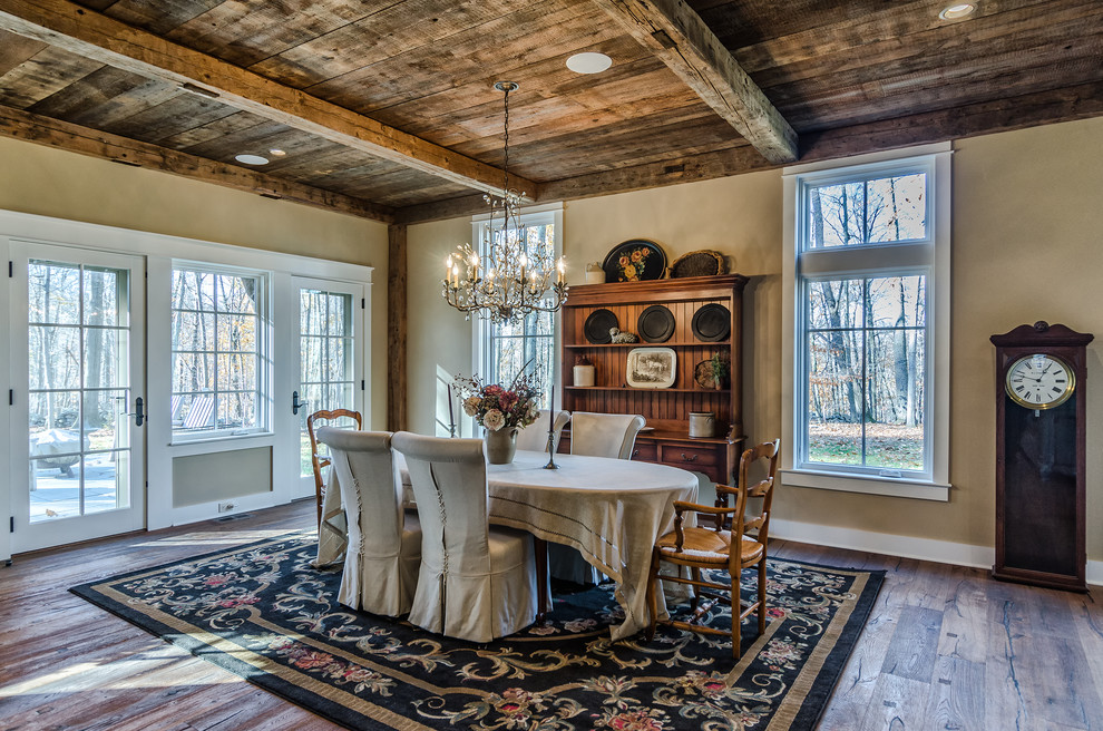 Immagine di una sala da pranzo stile rurale con pareti beige e parquet scuro