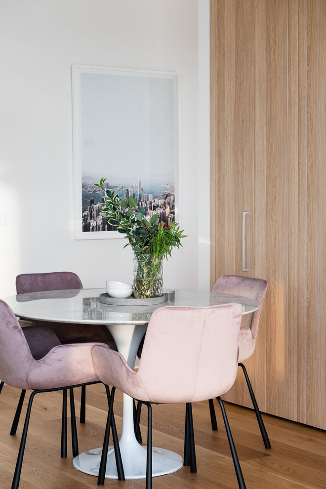 Modernes Esszimmer mit weißer Wandfarbe, braunem Holzboden und braunem Boden in Melbourne