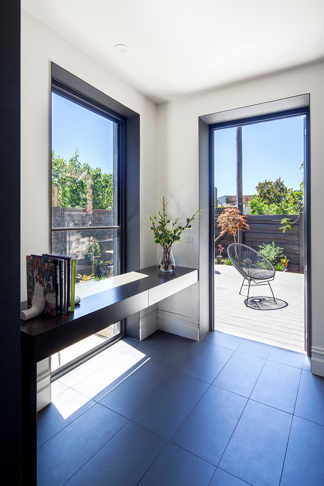 This is an example of a modern open plan dining room in Melbourne with white walls, concrete flooring and grey floors.