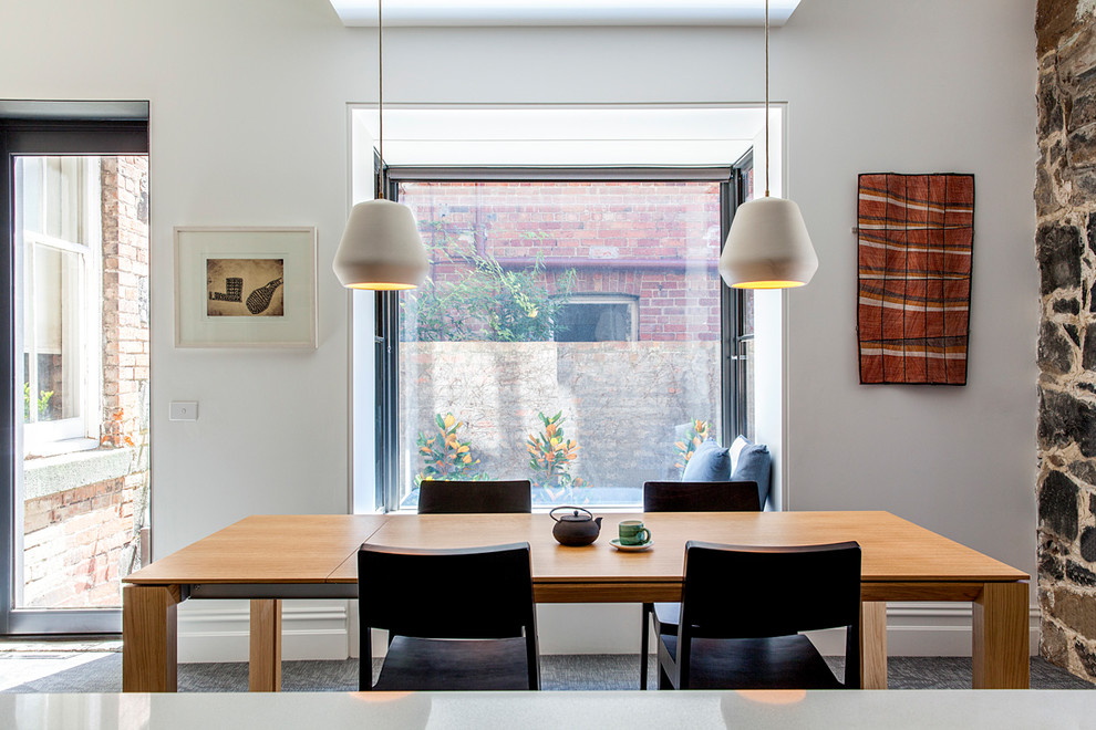 Foto di una sala da pranzo aperta verso il soggiorno design di medie dimensioni con pareti bianche e pavimento grigio