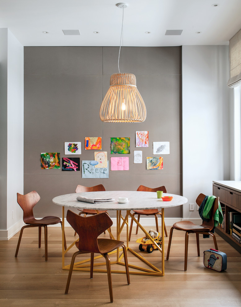 Réalisation d'une salle à manger design avec un mur gris et un sol en bois brun.