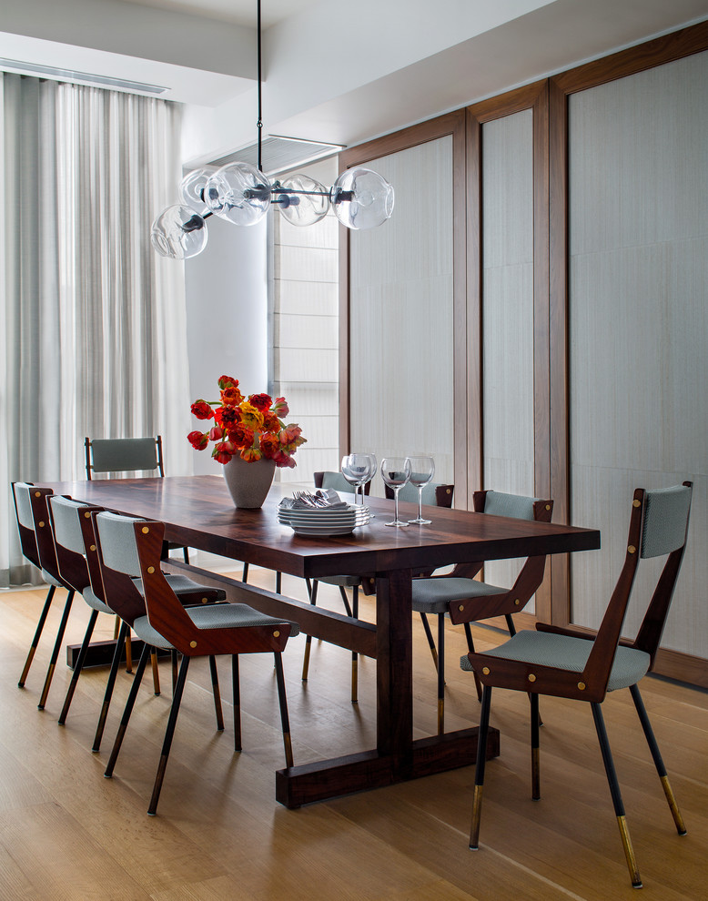 This is an example of a contemporary dining room in New York with medium hardwood flooring.