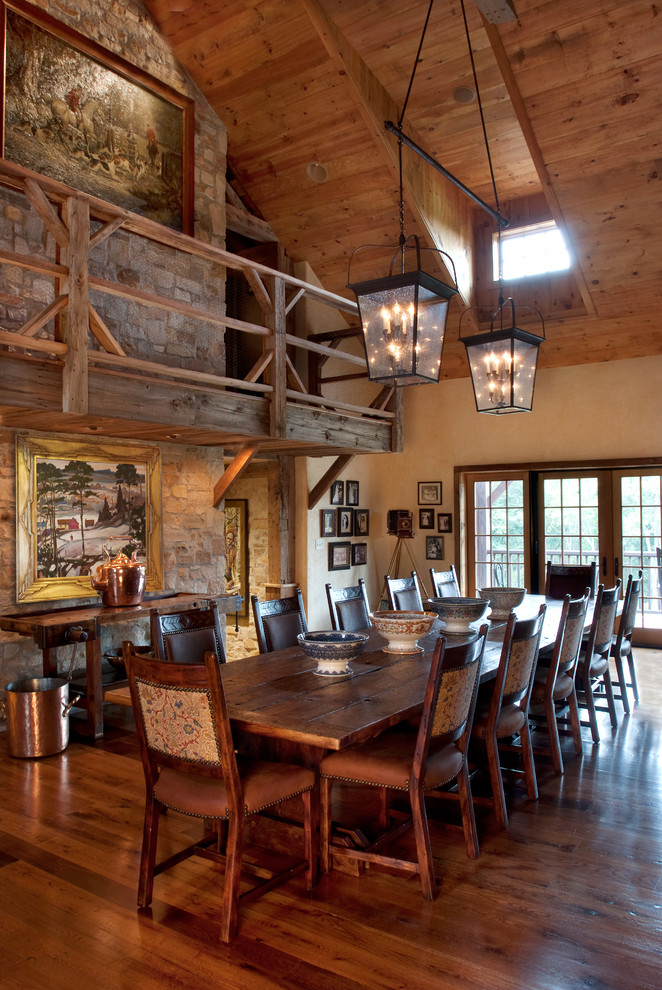 Foto di una grande sala da pranzo aperta verso la cucina country con pavimento in legno massello medio, nessun camino e pareti beige