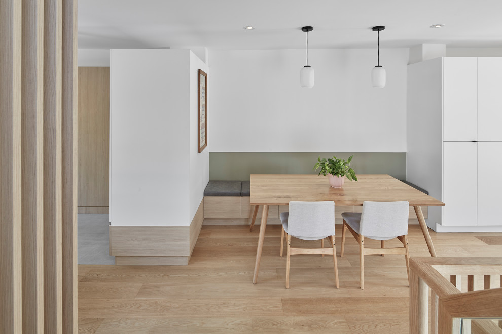 Foto di una piccola sala da pranzo aperta verso il soggiorno nordica con pareti bianche e parquet chiaro