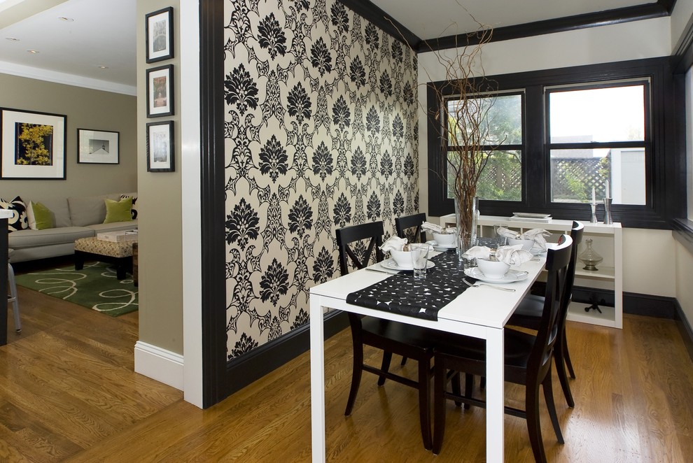 Aménagement d'une salle à manger ouverte sur le salon contemporaine avec un mur multicolore et un sol en bois brun.