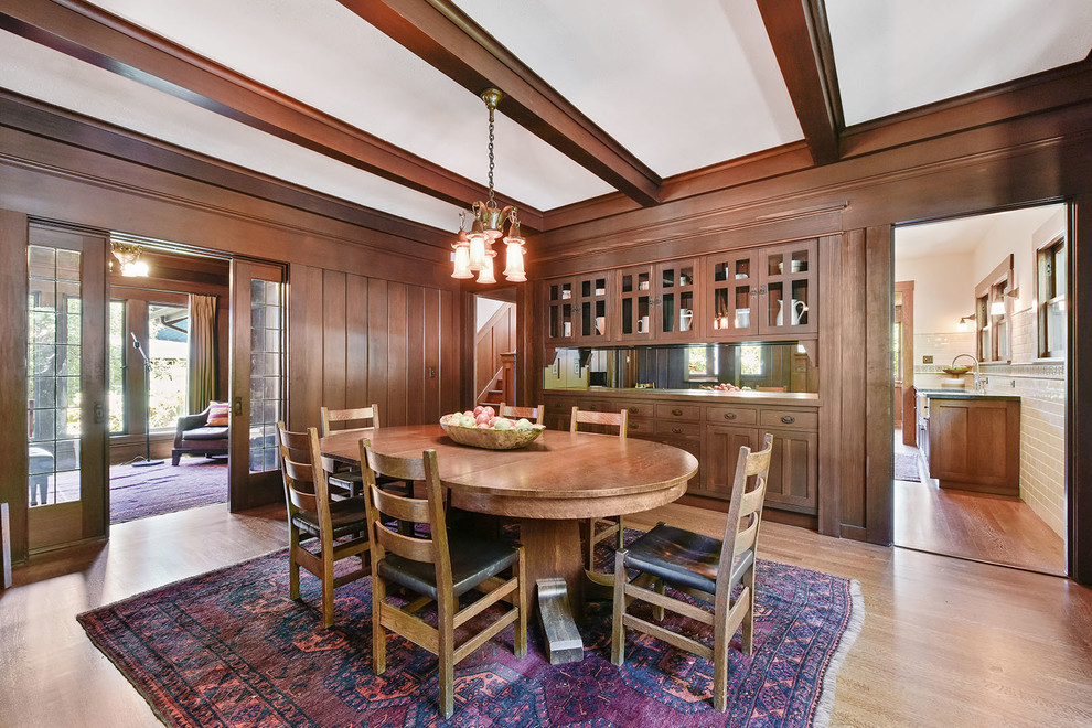 Idée de décoration pour une salle à manger craftsman fermée et de taille moyenne avec un mur beige, un sol en bois brun et un sol beige.