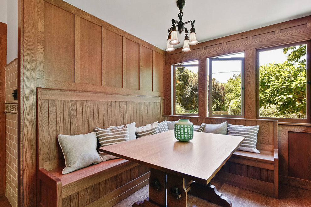 Immagine di una piccola sala da pranzo stile americano con pavimento in legno massello medio, pareti marroni, nessun camino e pavimento marrone