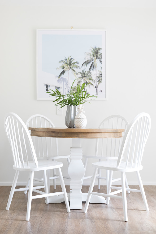 Idée de décoration pour une salle à manger design avec un mur blanc et parquet clair.