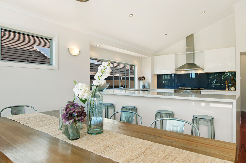 Esempio di una sala da pranzo aperta verso il soggiorno stile marino con pareti bianche e pavimento in legno massello medio