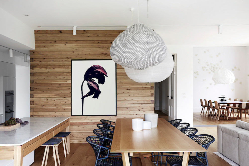 Immagine di una sala da pranzo aperta verso il soggiorno design con pareti marroni, parquet chiaro e pavimento beige
