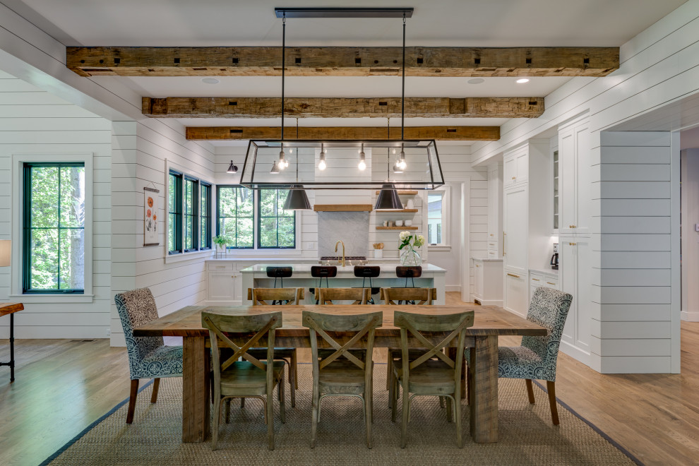 This is an example of a large farmhouse open plan dining room in Other with white walls, medium hardwood flooring and beige floors.