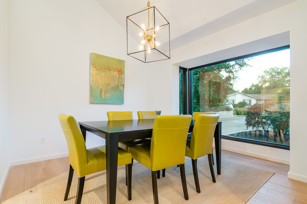 Photo of a medium sized modern enclosed dining room in Austin with white walls, light hardwood flooring and no fireplace.