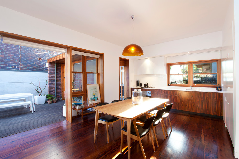 Trendy dark wood floor kitchen/dining room combo photo in Sydney with white walls