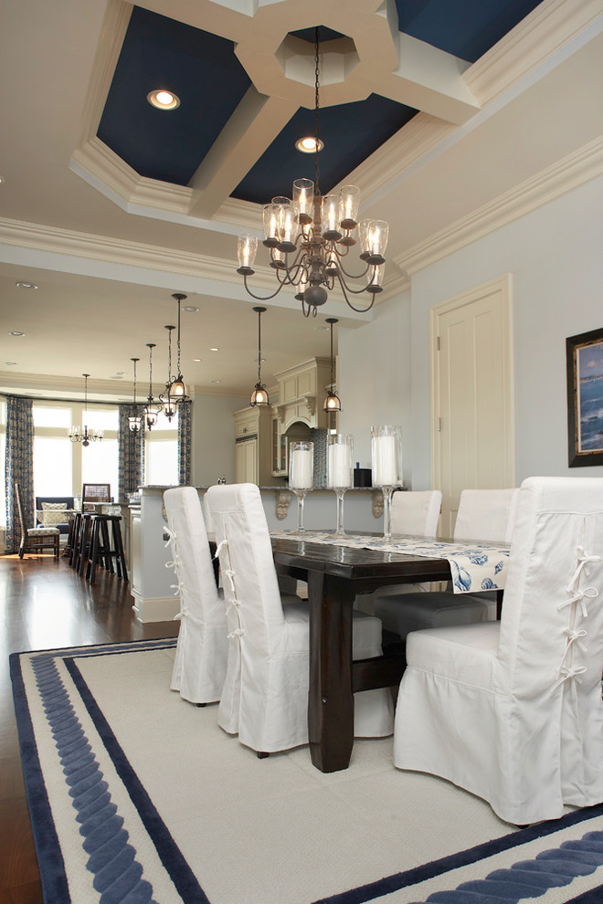 Exemple d'une salle à manger ouverte sur la cuisine bord de mer de taille moyenne avec un mur blanc, parquet foncé et aucune cheminée.