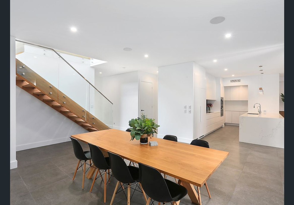 This is an example of a coastal open plan dining room in Sydney.