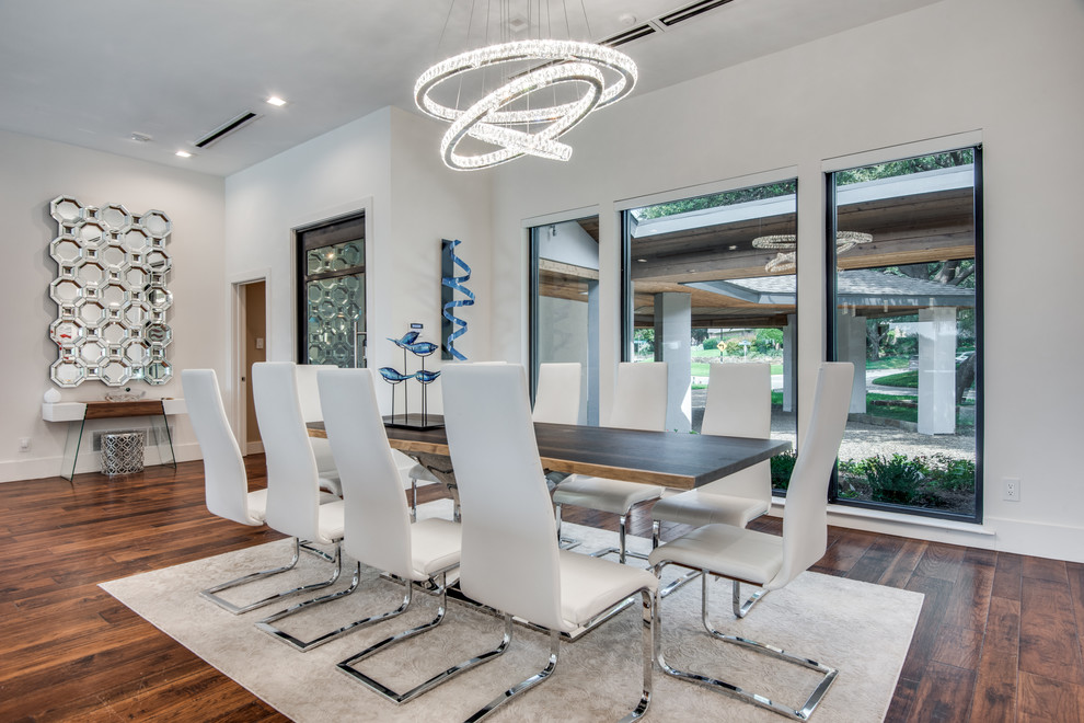 This is an example of a contemporary dining room in Dallas with white walls, dark hardwood flooring and brown floors.