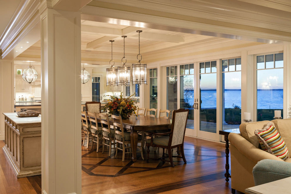 Idées déco pour une salle à manger ouverte sur la cuisine bord de mer avec un mur blanc, un sol en bois brun et un sol marron.