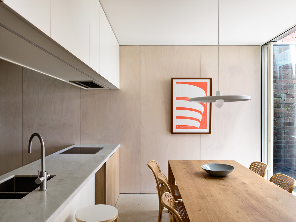 Modern inredning av ett kök med matplats, med beige väggar, betonggolv och grått golv