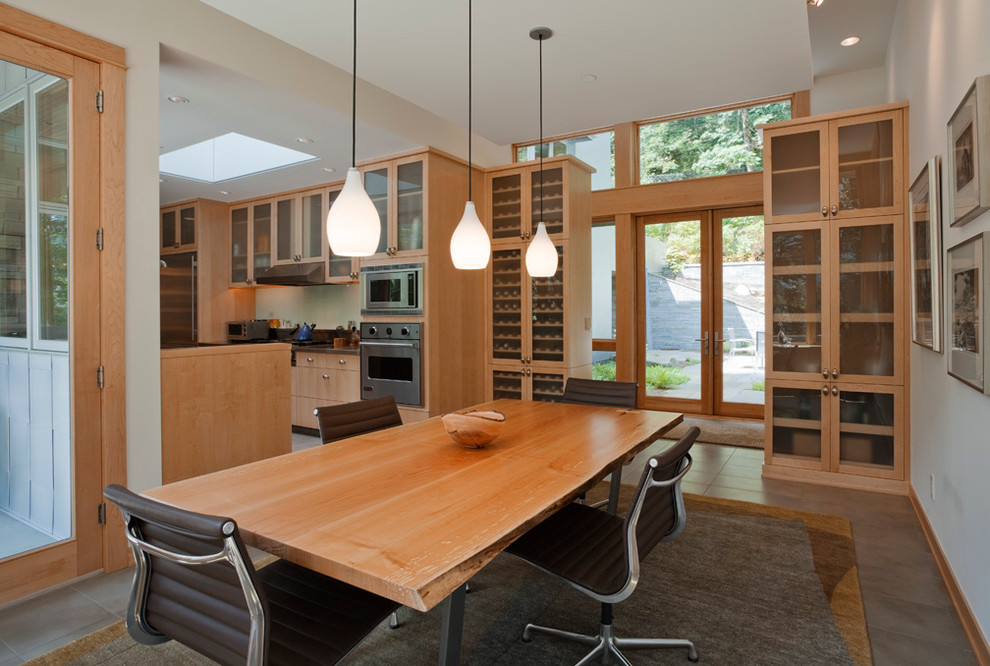 Immagine di una sala da pranzo aperta verso la cucina design con pareti bianche, pavimento in gres porcellanato e nessun camino