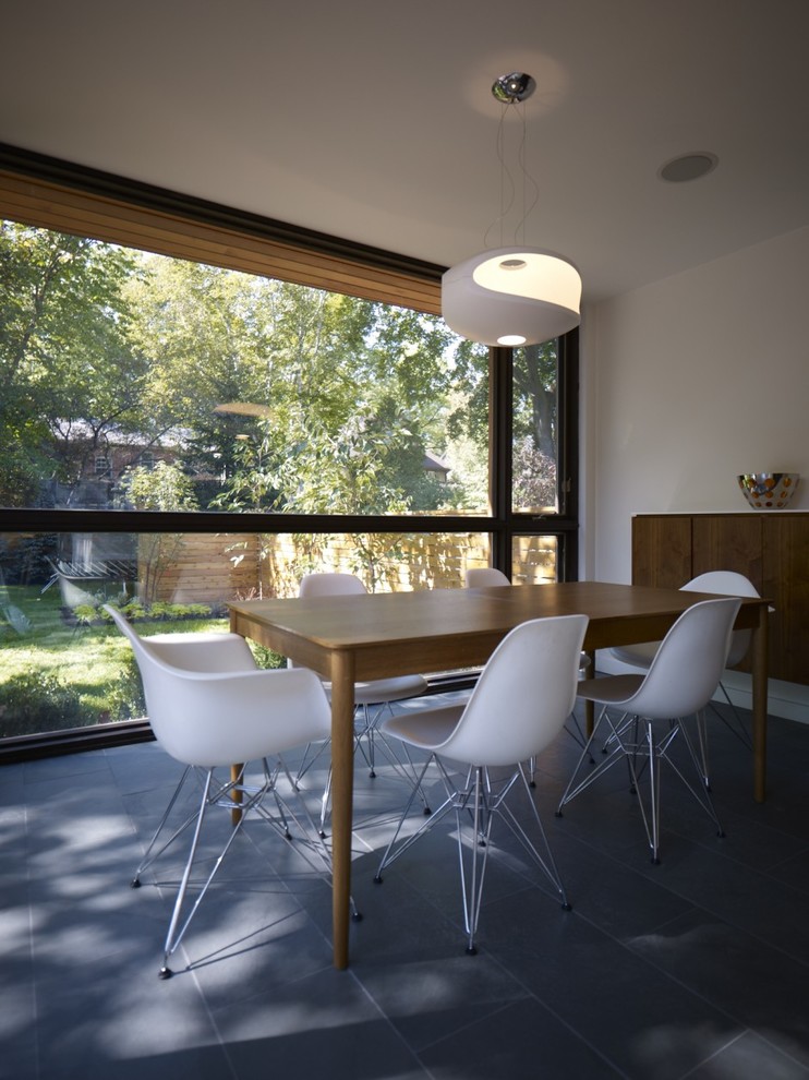 Foto di una sala da pranzo aperta verso la cucina design di medie dimensioni con pareti beige, pavimento in ardesia e pavimento grigio