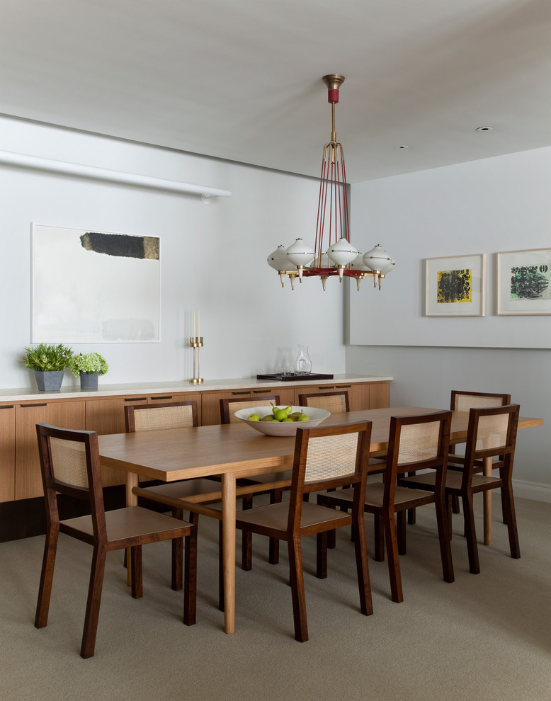 Esempio di una sala da pranzo minimalista con pareti bianche e moquette