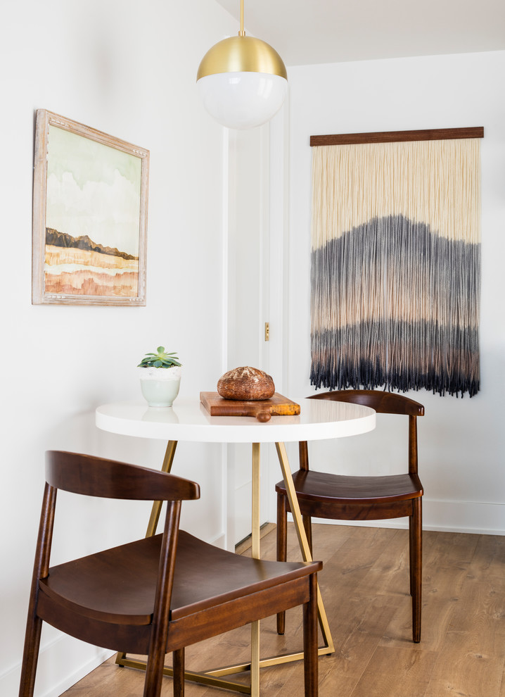 Example of a small danish laminate floor and brown floor kitchen/dining room combo design in Seattle with white walls and no fireplace