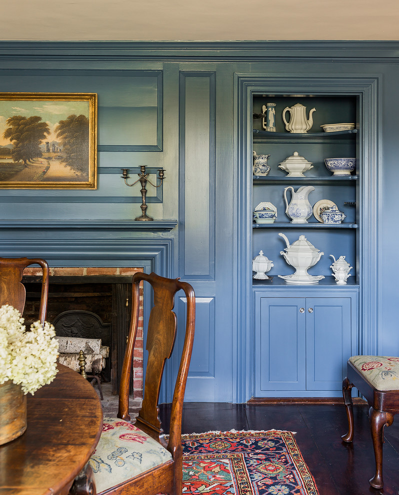 Ispirazione per una sala da pranzo classica chiusa con pareti blu, pavimento in legno massello medio e camino classico